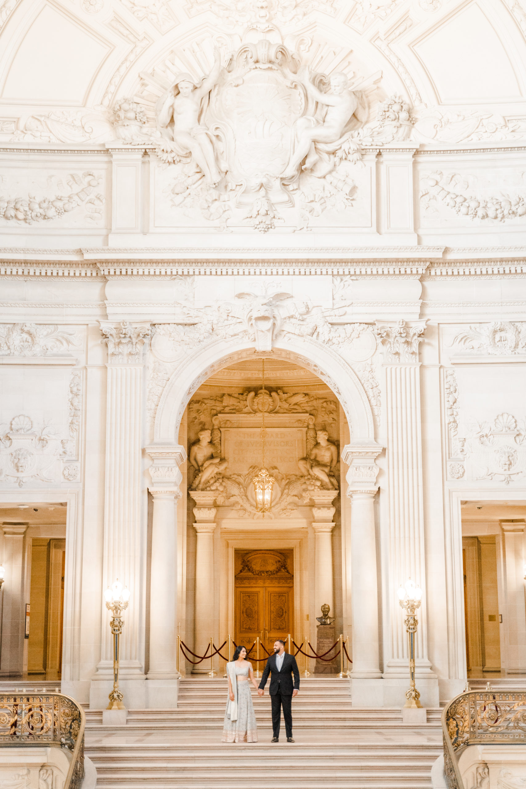 Bride and Groom posing on San Francisco City Hall stairs