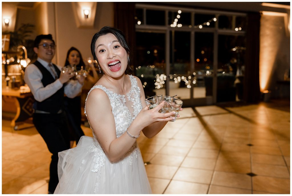 Bride holding drinks during her Elegant Wedding Reception in California