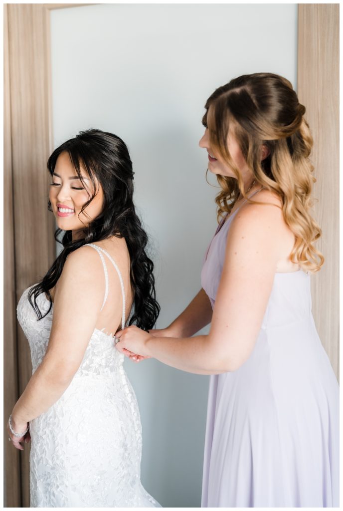Maid of Honor Helping Bride put on dress before Sequoyah Country Club Wedding